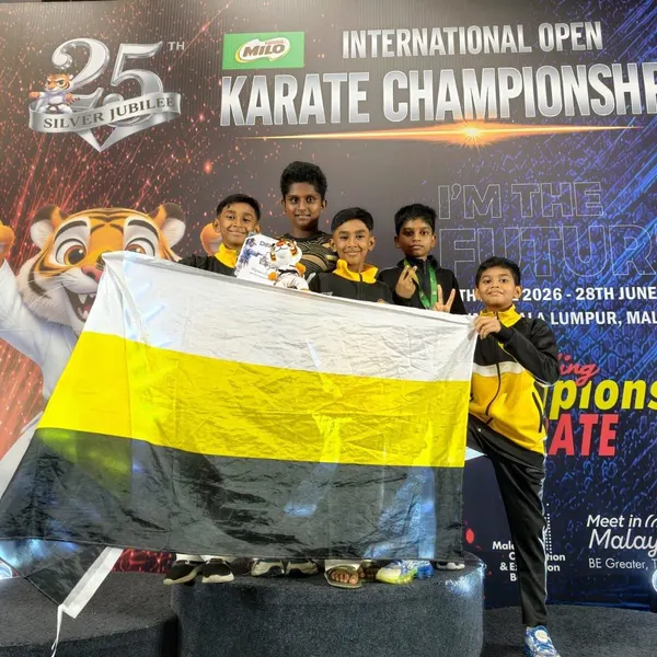 Perak Legends students on the podium holding the Perak state flag