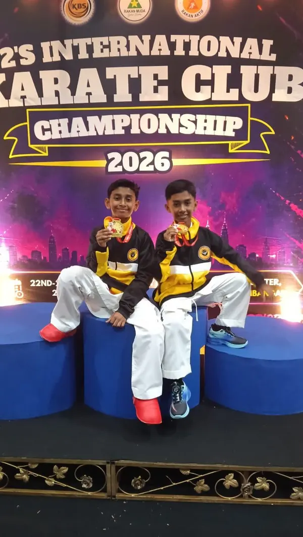 Two Perak Legends students sitting on the podium with their medals